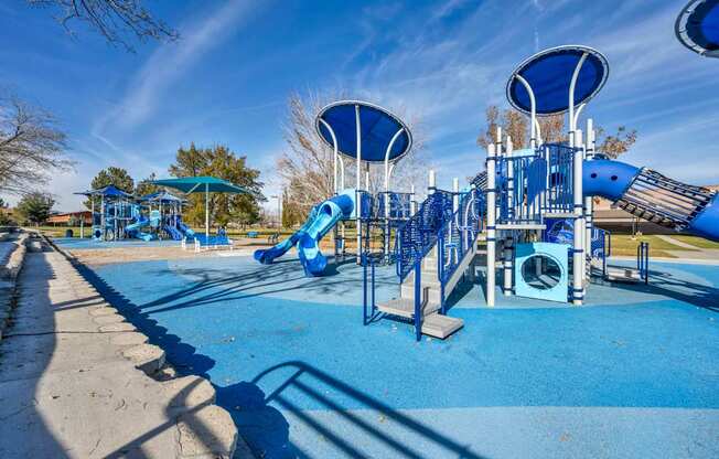 A playground with a blue slide and a climbing frame.