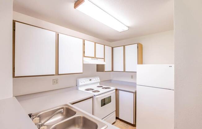 A kitchen with white appliances and cabinets.