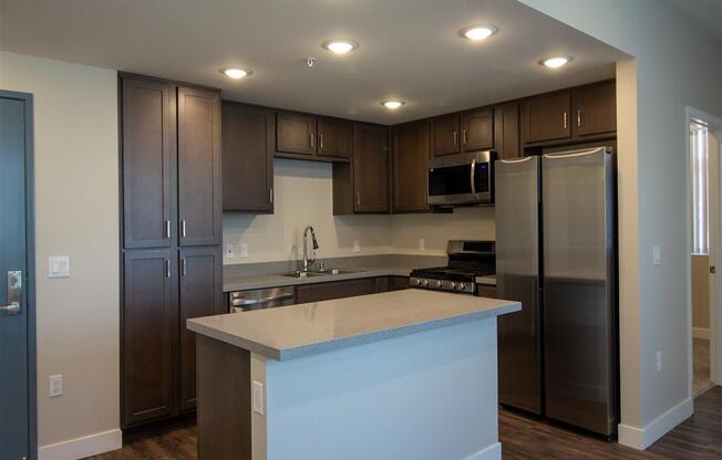 kitchen with dark wood cabinets and a white counter top at Loma Villas Apartments in San Bernardino, CA