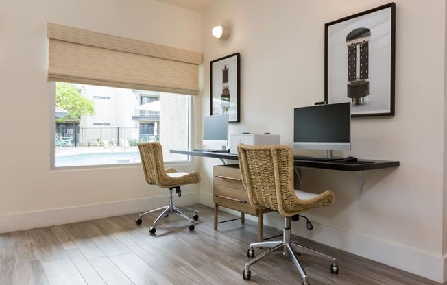 a home office with two chairs and a desk with a computer