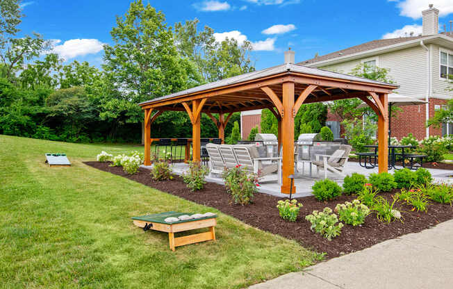 A wooden pergola is in a grassy backyard.