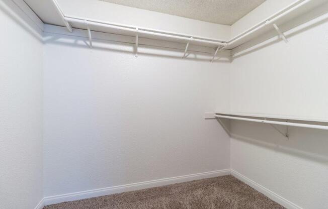 a walk in closet with a hanging rack on the wall