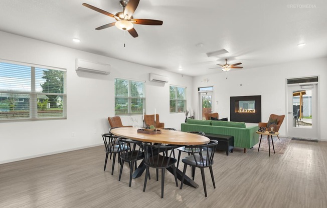 A room with a table and chairs and a ceiling fan.