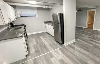 a kitchen with white cabinets and a stainless steel refrigerator