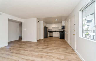 Model Living Room and Kitchen with Wood-Style Flooring at Palmilla Apartments located in San Diego, CA.