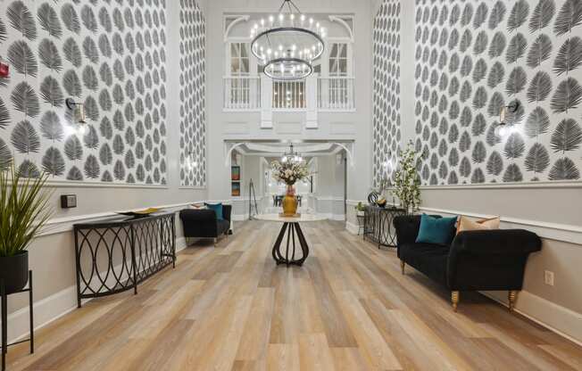 the lobby of a hotel with a large hall with chairs and a table