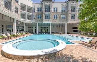 a large swimming pool in front of an apartment building