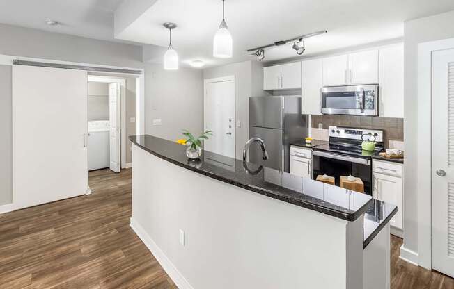 A modern kitchen with a white island and stainless steel appliances. at West Inman Lofts, Atlanta
