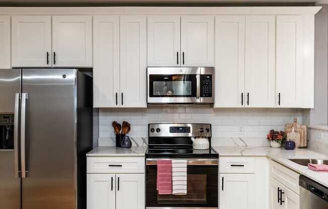 a kitchen with white cabinets and stainless steel appliances