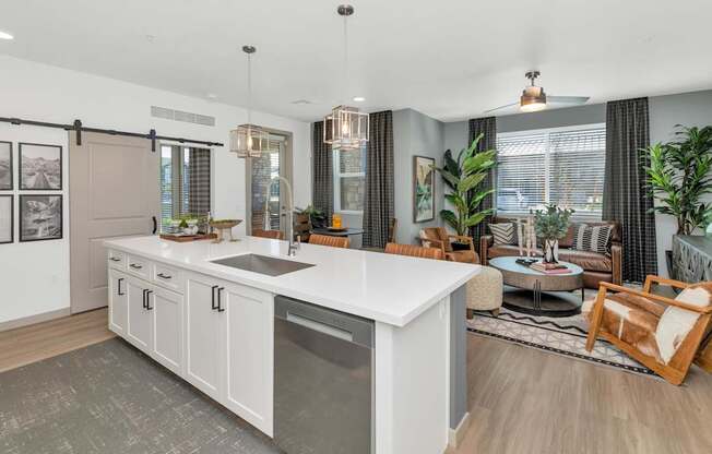 A modern kitchen with a large island and a dining area with a table and chairs.