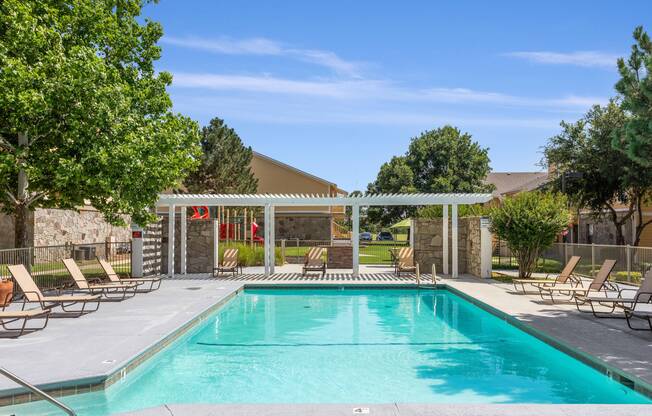 Resort-style swimming pool and sundeck with pergola at Edmond, Oklahoma apartments