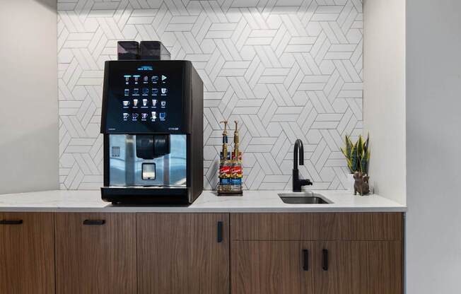 A black coffee machine is on a counter with a white background.