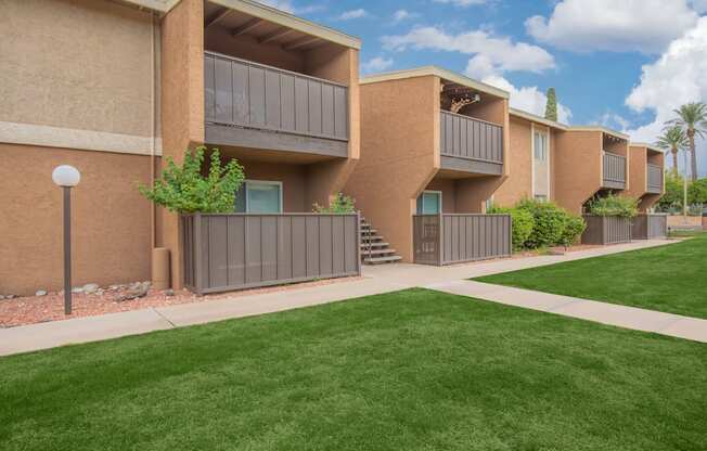 Apartment complex with green lawn in front.