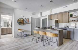 Kitchen with counter-height island, wood tone flooring, and designed furnishings