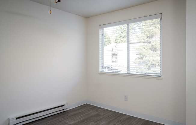 a bedroom with white walls and a large window