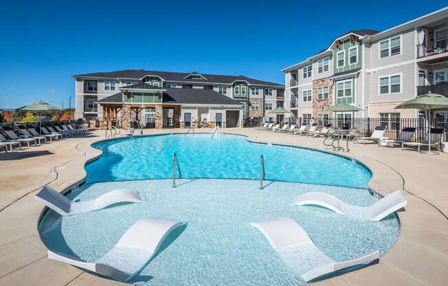 a large swimming pool in front of an apartment building