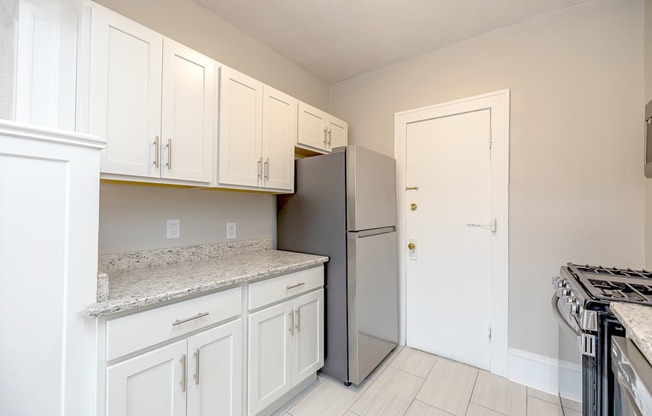 Lewis Manor updated kitchen with white cabinets and a granite countertop.