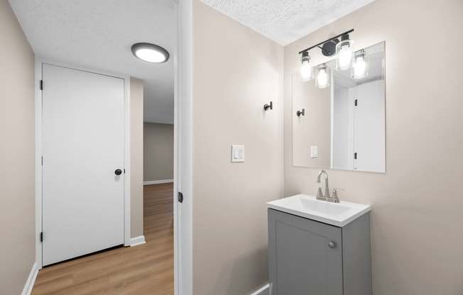 A bathroom with a white sink and a white door.