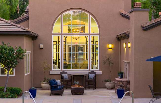 A patio with a table and chairs is set up outside a house.