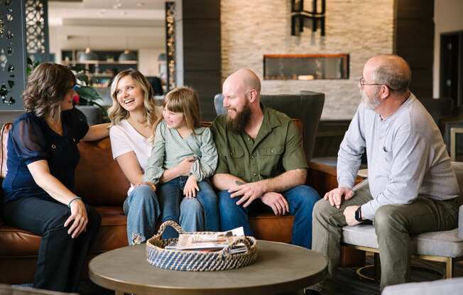 a family sits on a couch in a hotel lobby  at Harbor Heights 55+ Community, Washington