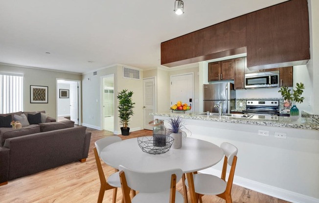 a living room and kitchen with a white table and chairs