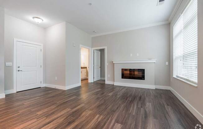 A room with a fireplace and wood flooring.at Century Baxter Avenue, Louisville Kentucky