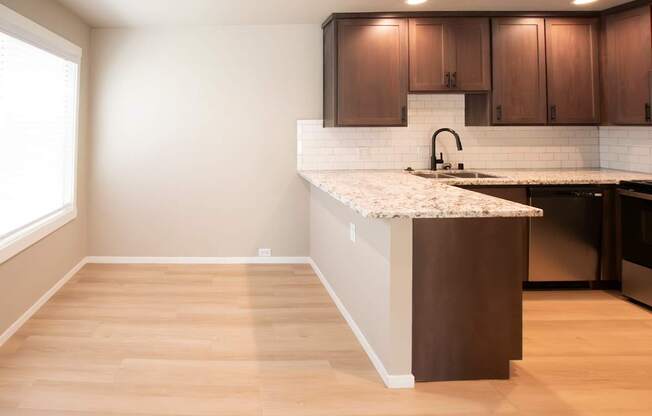 A kitchen with a white countertop and wooden cabinets.