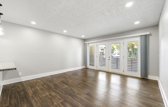 Living room with updated flooring and private patio at Balfour Chastain, Sandy Springs, GA