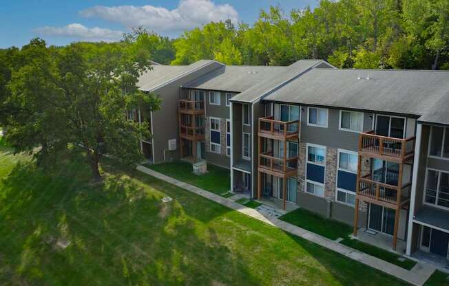 A row of modern townhouses with balconies and trees in the background.