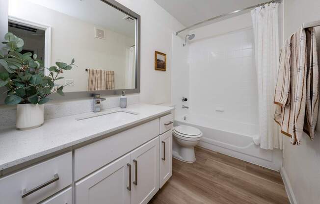A bathroom with a toilet, sink, and bathtub.