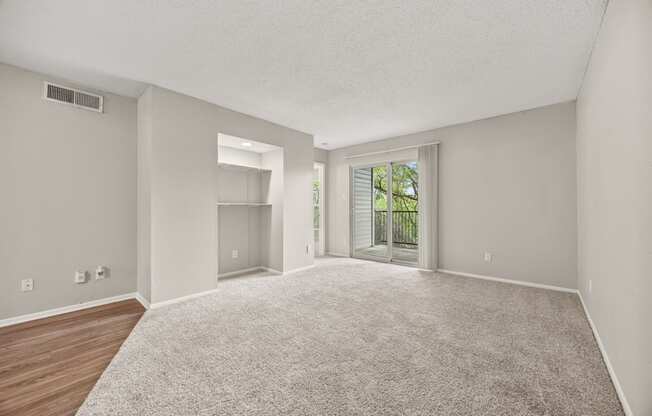 A spacious room with a carpeted floor and a sliding glass door leading to a balcony. at Montecito, Austin, TX, 78741