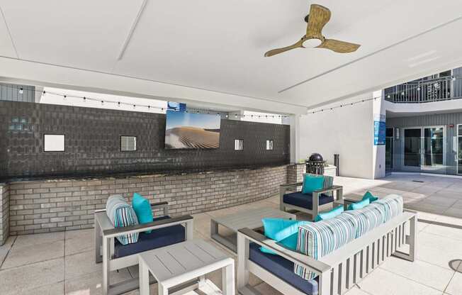 A patio with a table and chairs and a ceiling fan.