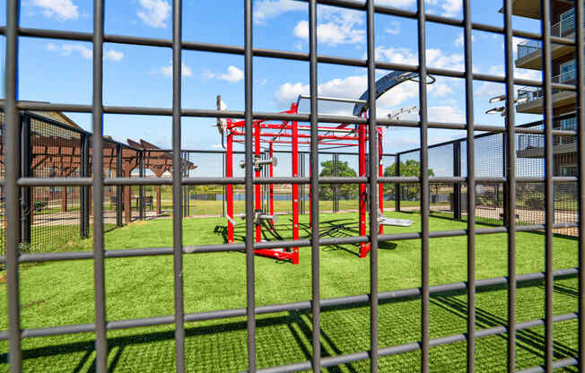 a view of a playground from behind a prison fence