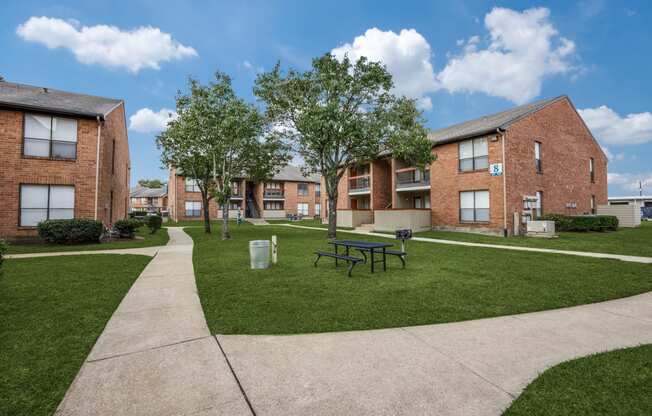 a rendering of a courtyard in front of a row of brick buildings