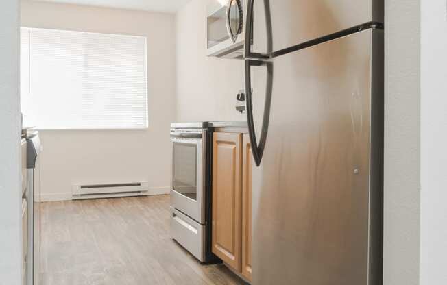 a renovated kitchen with stainless steel appliances and wood flooring