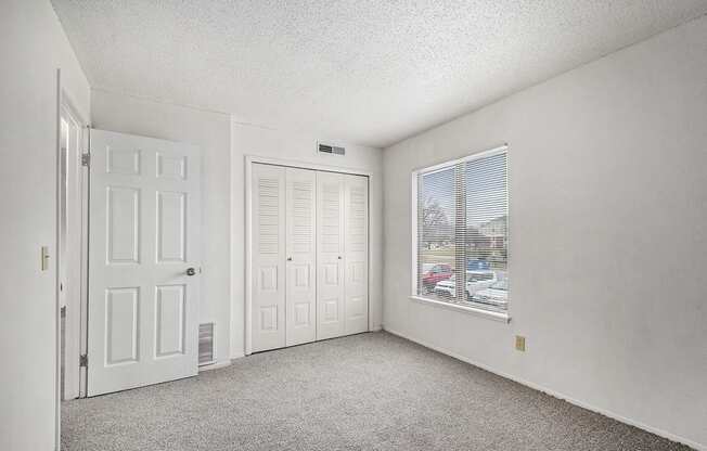 an empty living room with a window and a door