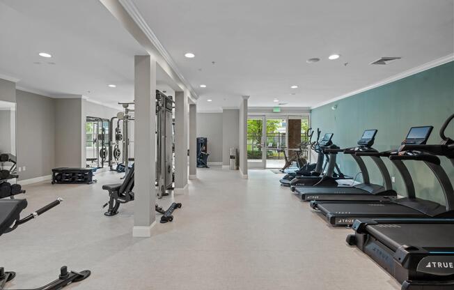 Well-equipped fitness center featuring a full lineup of cardio machines, strength-training equipment, and open space for a variety of workout styles.
