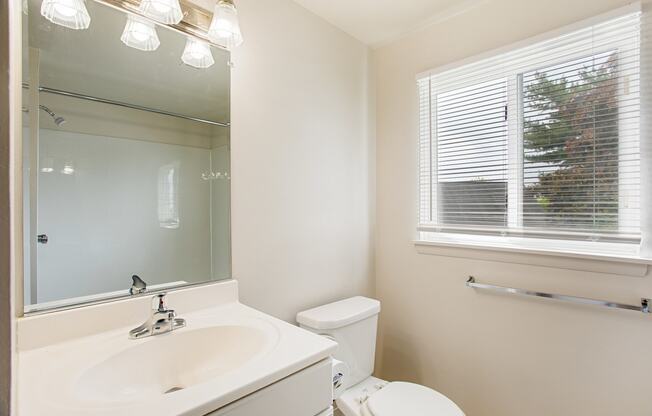 renovated bathroom with white vanity and window