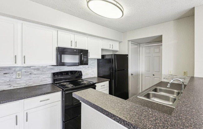 A3 floor plan kitchen with black appliances Jefferson Creek Apartments in Irving, TX.