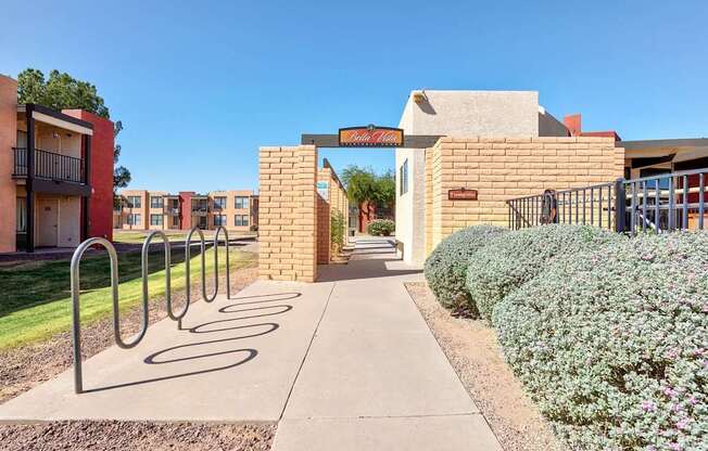 A pathway leads to a building entrance with a metal railing on the left.