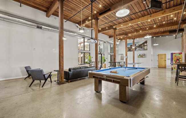 a pool table in a large room with a couch and chairs