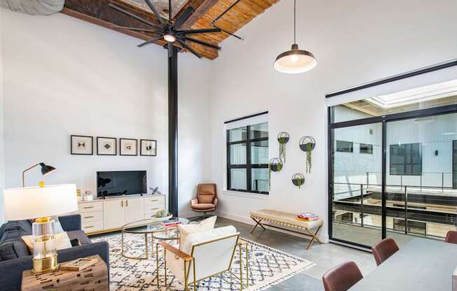 A living room with a dark blue sofa, a wooden coffee table, and a TV on the wall.