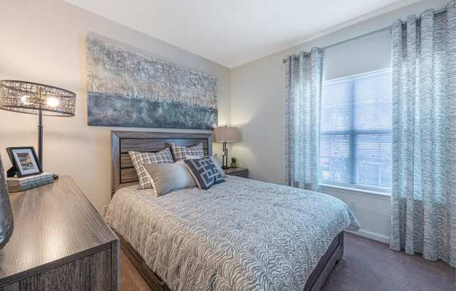 a bedroom with a bed and a large window