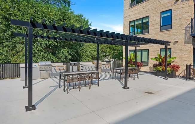 a patio with a pergola and tables and chairs