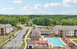 A large apartment complex with a swimming pool in the middle and many covered lounge areas