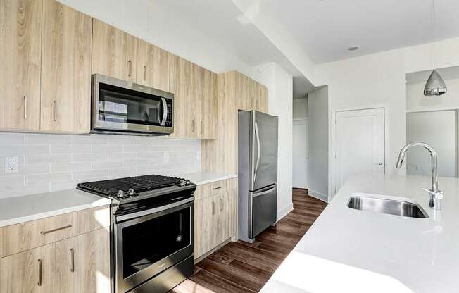 A modern kitchen with wooden cabinets and stainless steel appliances.