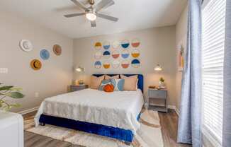 Summermill at Falls River Apartments bedroom with large bed and ceiling fan