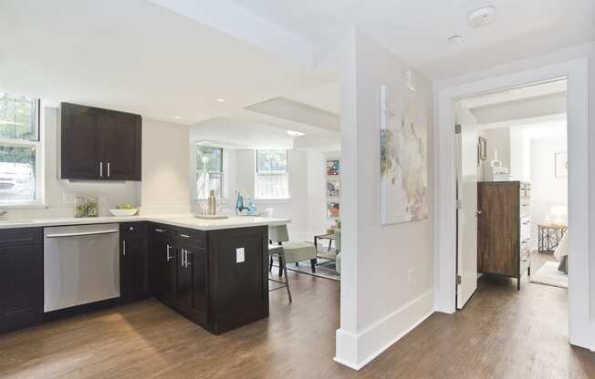 kitchen with black cabinets and a white counter top and a living room