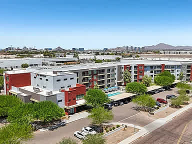 A large apartment complex with a parking lot in front.