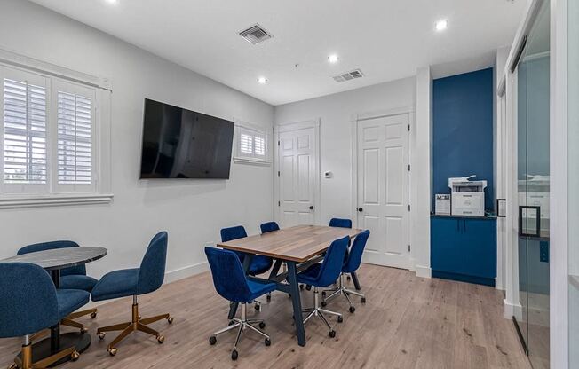 a conference room with a table and chairs and a tv